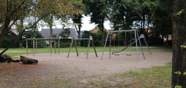 Zona de juegos en el patio de la escuela, con columpios y tobogán