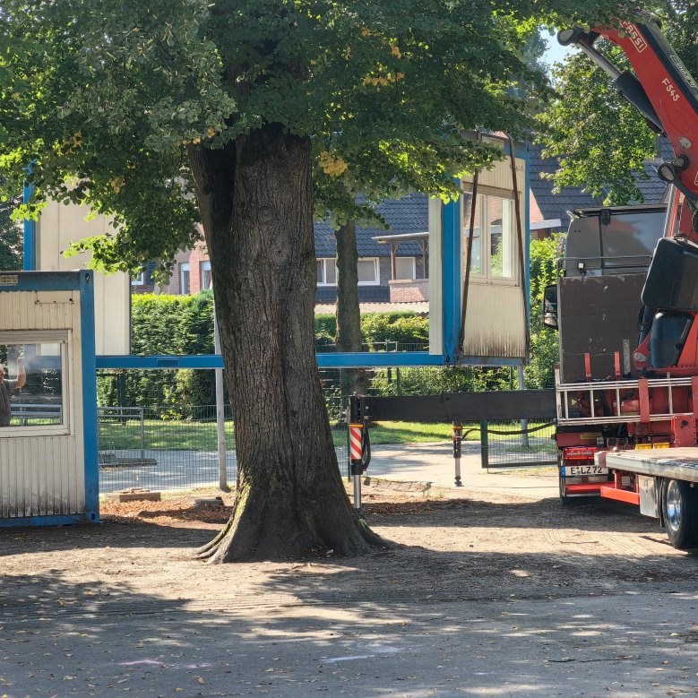 Endised konteinerid kantakse kraanaga veoautole ja viiakse ära.