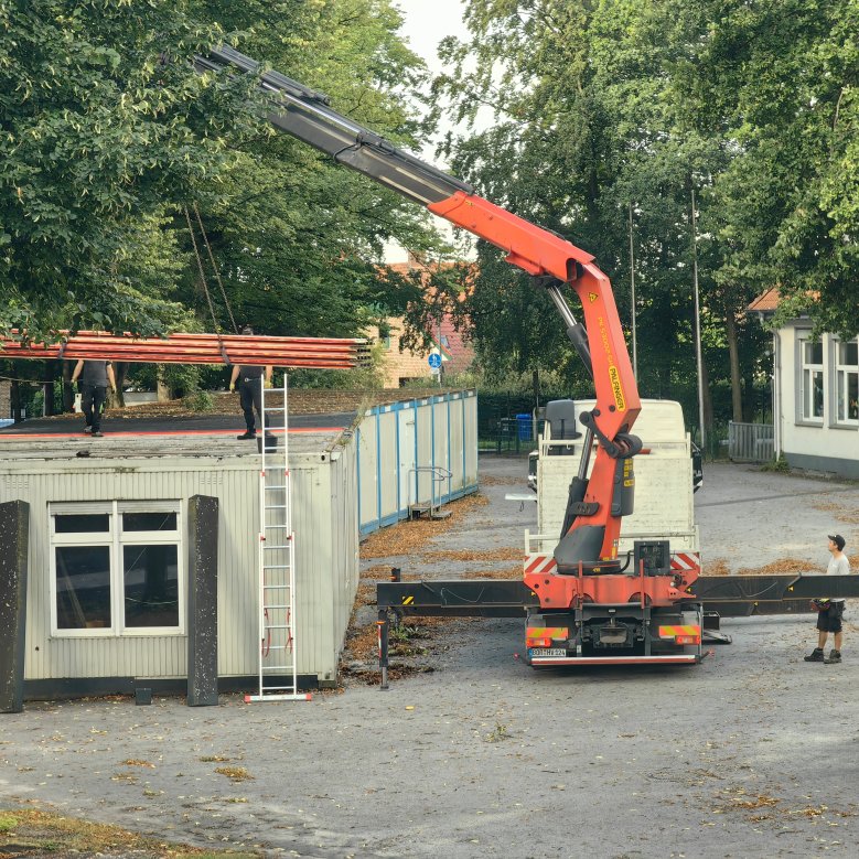 les anciens conteneurs sont portés par la grue sur le camion et enlevés