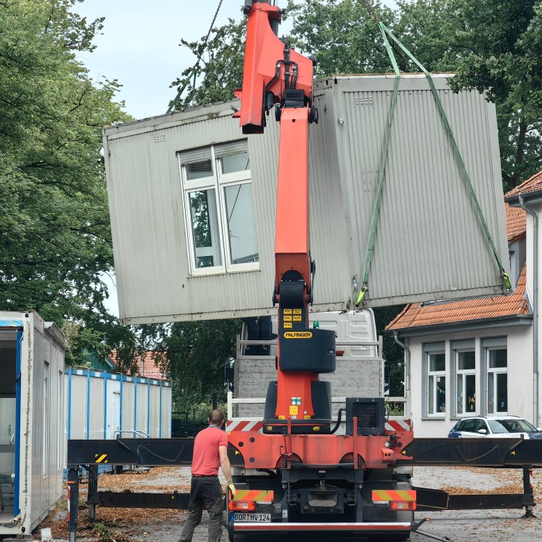les anciens conteneurs sont portés par la grue sur le camion et enlevés