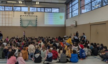 Les enfants chantent assis dans le gymnase