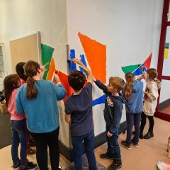 I bambini dipingono le pareti della scuola