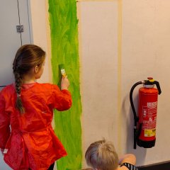 Bērni krāso sienu