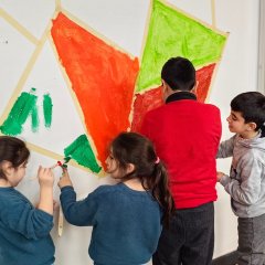 Kinderen schilderen de muur