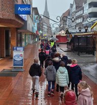 Dzieci idą w szeregu przez miasto w kierunku kościoła protestanckiego