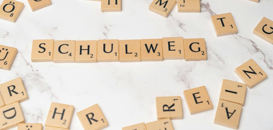 Kamienie Scrabble tworzą słowo "trasa szkolna"