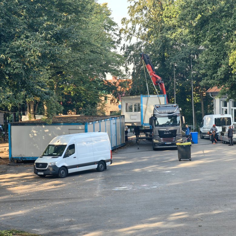 Os antigos contentores são transportados para o camião por uma grua e retirados
