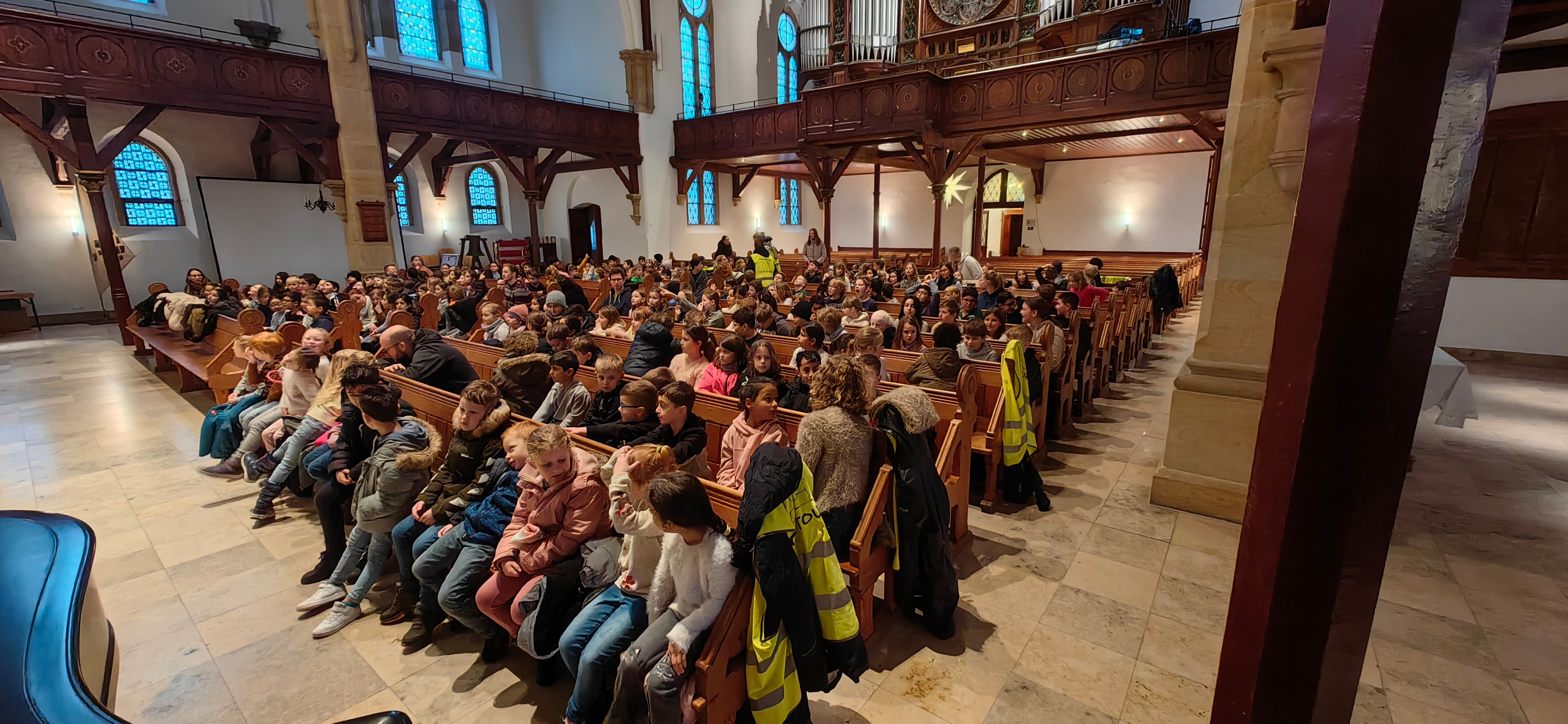 eleverna sitter i bänkarna i kyrkan