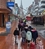 Kinder laufen in einer Reihe durch die Stadt in Richtung evangelischer Kirche